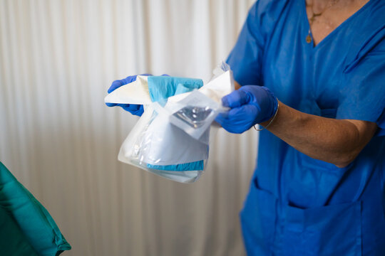 Medical professional opening sterile surgical equipment package