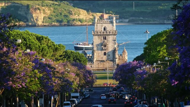 Jacaranda trees bloom near Belem Tower at sunset in Lisbon, Portugal