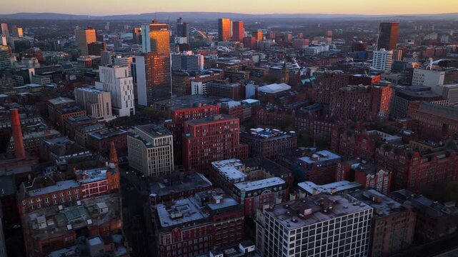 Aerial video of Manchester at sunrise, showing the urban density of the downtown area as golden light hits the city's diverse architecture.