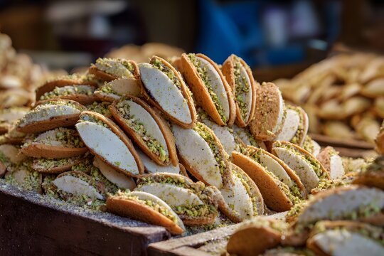 Silica dusted market deep Morocco yield mystical succulent Makroud cake sweet almond paste sandwich filling infused into delicate wafer thin cooky made of finest pistachio crumb clean professional