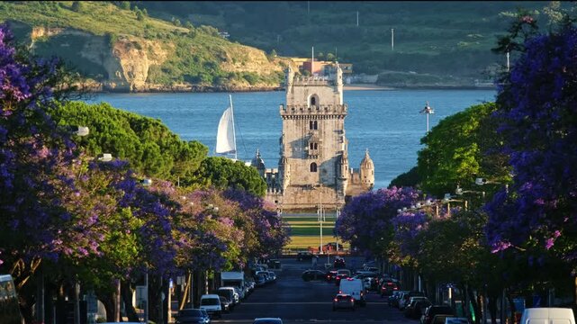 Jacaranda trees bloom near Belem Tower at sunset in Lisbon Portugal