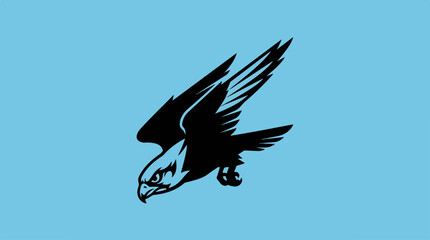 Fototapeta premium Silhouette of a falcon soaring against a light blue background.