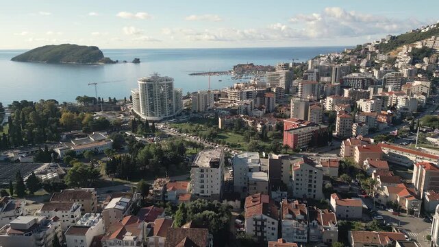 Aerial view of Budva city panorama and Adriatic sea coastline on a sunny day in Montenegro.