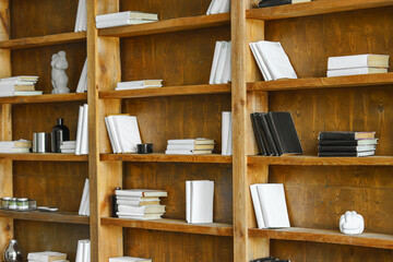 Large wooden bookshelves with books and minimal decor in modern loft library, cabinet or study interior. Natural wood texture, stylish workspace or reading area, contemporary office or business room © katyamaximenko