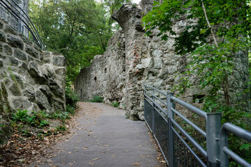 Fototapeta premium Dramatic low-angle view of the steep ascent to Drachenfels castle ruins. Massive historic stone walls towering over the hiking path in Konigswinter