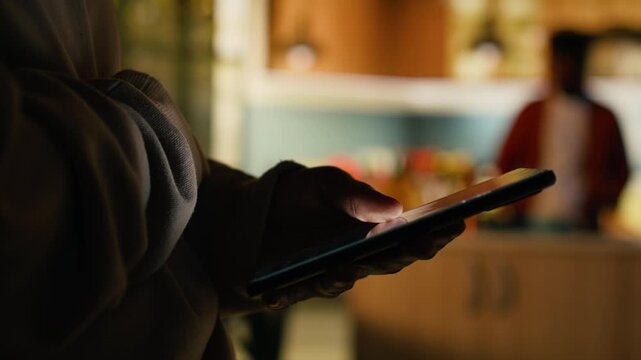 Adult black woman enjoying cozy moment at home and browsing apps on phone, calm domestic life indoors. Ambience focused on screen time and comfort, relaxing in the hallway.