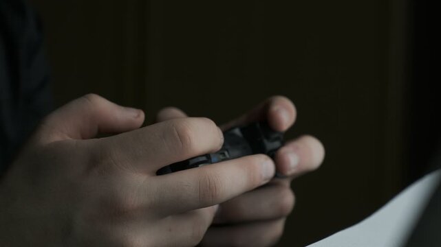 Young person playing video game using a game console controller