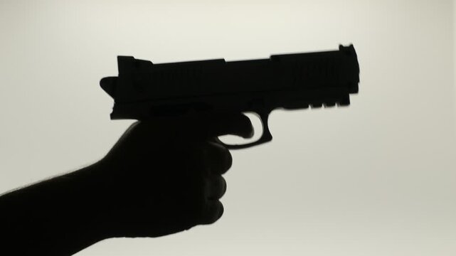 Person aiming and shooting a firearm, weapon and security concept