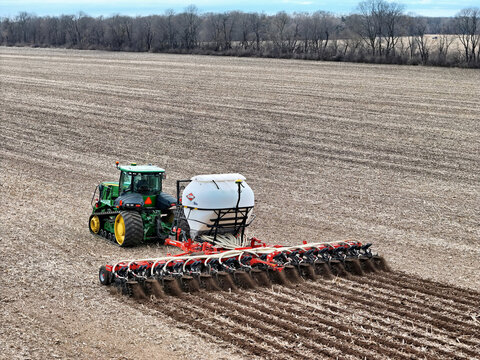 Roscoe, Illinois, April 1, 2026, John Deere 9560RT tracked tractor pulling a Kuhn Gladiator 1205 strip-tilling and fertilizing for spring planting.
