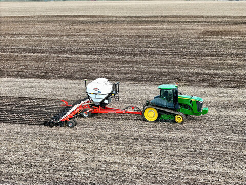 Roscoe, Illinois, April 1, 2026, John Deere 9560RT tracked tractor pulling a Kuhn Gladiator 1205 strip-tilling and fertilizing for spring planting.