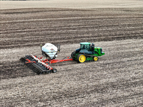 Roscoe, Illinois, April 1, 2026, John Deere 9560RT tracked tractor pulling a Kuhn Gladiator 1205 strip-tilling and fertilizing for spring planting.