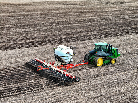 Roscoe, Illinois, April 1, 2026, John Deere 9560RT tracked tractor pulling a Kuhn Gladiator 1205 strip-tilling and fertilizing for spring planting.