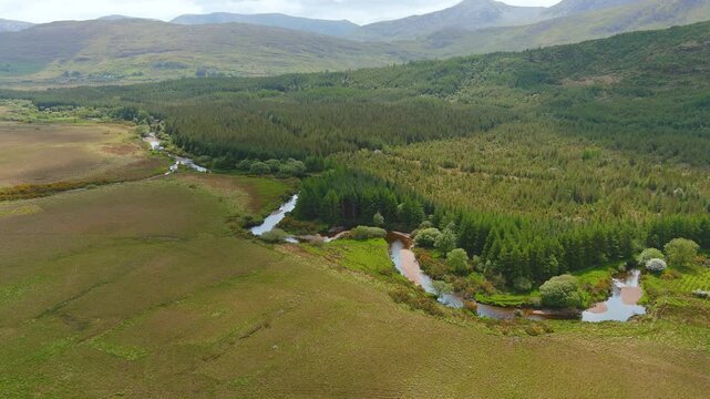 Aerial view of Joyce's river winding down below in Connemara region in Ireland. Scenic Irish countryside landscape, County Galway, Ireland.