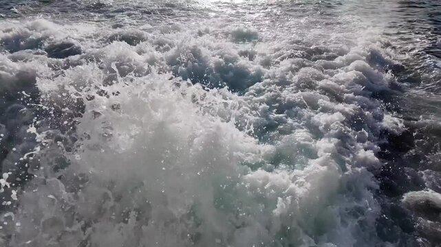 Powerful ocean waves create white foam and turbulent motion at sea.