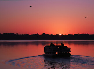 Fishermen Head Out in Their Pontoon Boat as The Sun Rises on the Lake © sdbower
