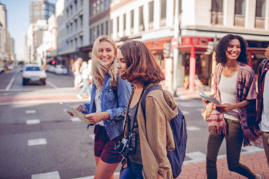 Group of young travelers crossing city street