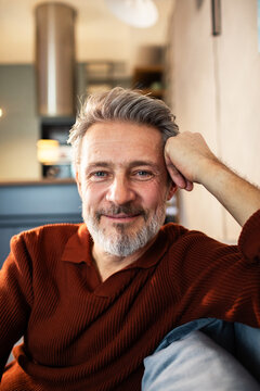 Smiling middle-aged man relaxing at home