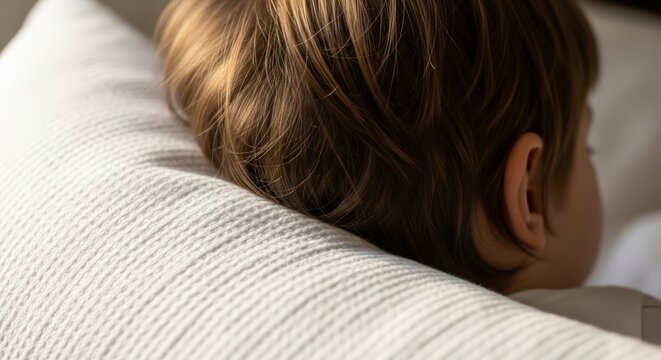 child resting head on pillow sleeping.