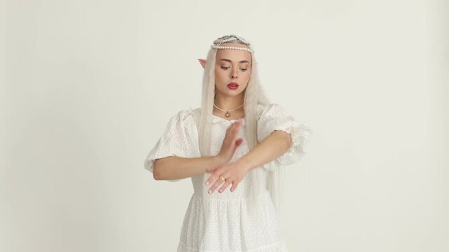 Beautiful girl dressed as elf on white background
