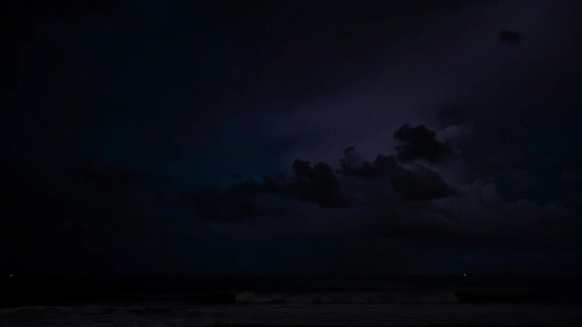 Lightning strikes over dark ocean water.