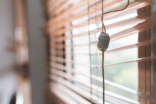 Close-ups of window blinds with a pull cord and partially broken blinds creating interesting light and shadow patterns.