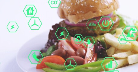Showcasing centered white plate on tabletop with sesame burger, fries, salad, green hexagon icons © vectorfusionart