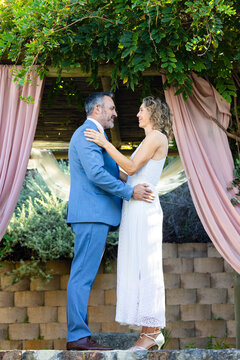 Vertical video: Couple vowing under pergola music starting animated petals circling marking wedding