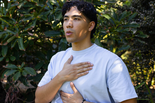 Man pressing chest and abdomen amid foliage, activating animated health overlay showing heart rate