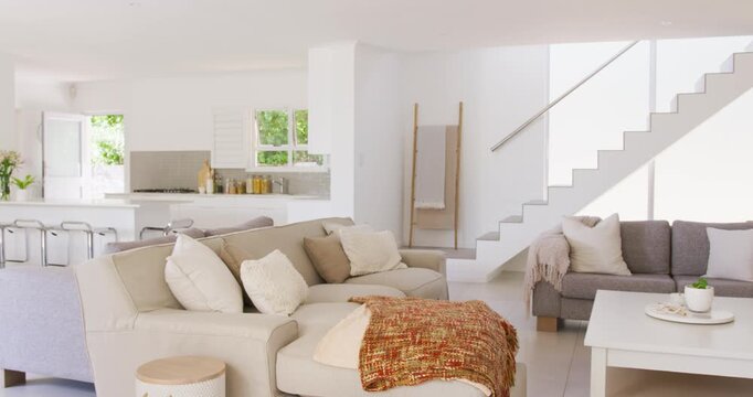 Camera starting right pan revealing beige sofa at home with rust-throw, coffee-table showing style