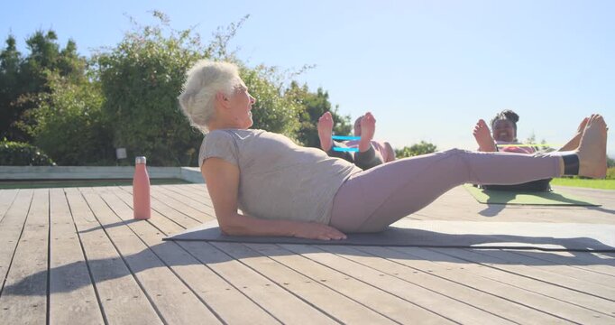 Senior woman, 2 women following cue propping leg-lifting for core on wooden deck mats, copy space