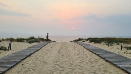 Coucher de soleil rouge au-dessus d'une plage de la presqu'île du Cap Ferret vu depuis le haut de la dune un soir d'été (côte atlantique) © Arnaud