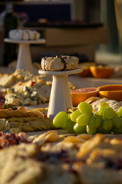 Lavish charcuterie board and grazing table with cheeses, fruits, and cold cuts.