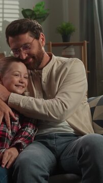 Caucasian happy family dad male girl daughter relaxing on couch at home hugging parent kid father in living room man touching nose of child cuddling love relationship custody adopt childcare bonding
