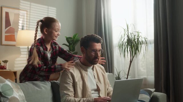Angry busy father man working at home laptop noisy little girl daughter disturb Caucasian freelancer dad distant online job irritated male talk shouting bad behavior attention child kid family problem
