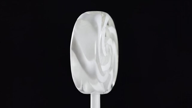 Closeup of a Swirled White Lollipop on a Black Background.