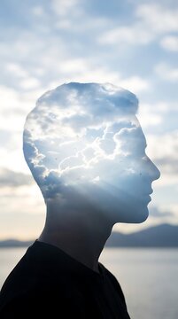 Double exposure of a mans profile with a cloudy sky symbolizing thought and consciousness.