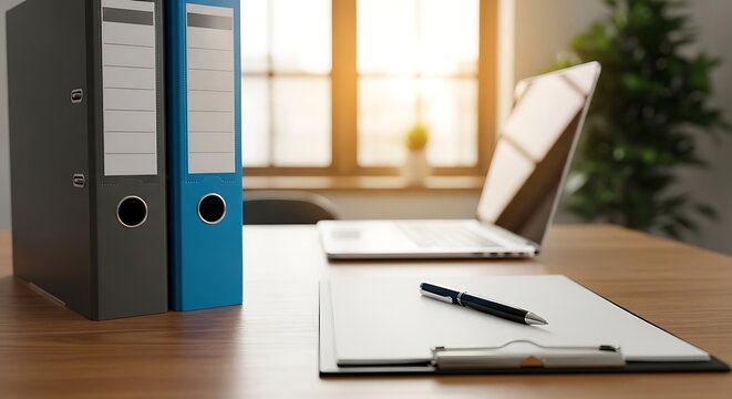Office workspace with laptop and binders on wooden desk for organization