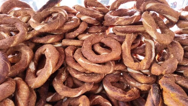 Stacks of freshly baked Turkish simit bagels displayed at a street food stall.