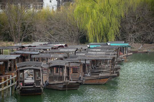 Classic wooden boats with black sails navigate the tranquil waterways of Wuzhen Water Town, reflecting the rich cultural heritage of China