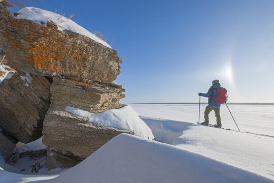 snowshoeing  along  cliffs, ice crystals in the air, Hecla/Grindstone Provincial Park, along Lake Winnipeg, Canada