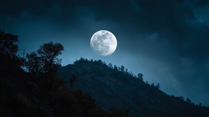 Fototapeta premium Full moon glowing in clear night sky above serene natural landscape, luminous lunar surface illuminating dark horizon with soft silver light, peaceful atmospheric scene with deep blue tones and celest