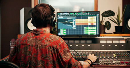 Back, computer screen and music with man in recording studio for production or sound engineering. Display, equipment and synthesizer with DJ person in control room for balance, editing or mixing © peopleimages.com