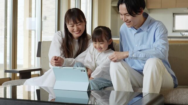 タブレットを見る家族　親子　夫婦　女の子