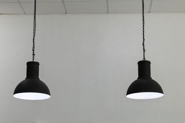 Obraz premium Black industrial-style hanging lights illuminate minimalist white interior