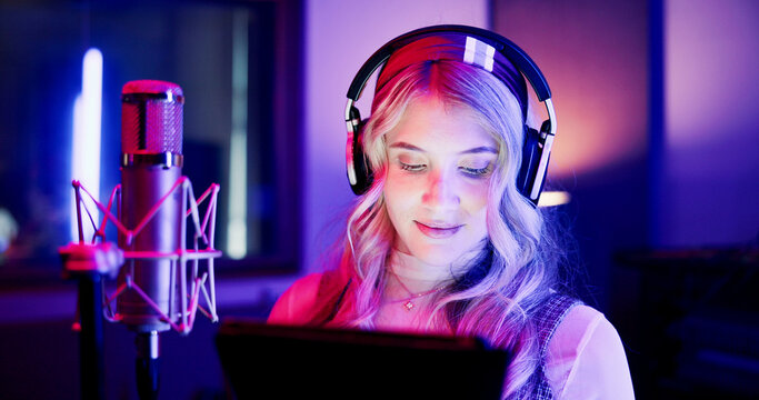 Woman, neon and broadcaster with mic on tablet for radio podcast or recording in production studio. Female person, announcer or journalist working late with technology or headphones for news on air