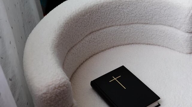 A closed Bible is lying on the chair