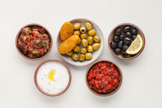 Turkish mezze assortment with red lentil kofte, olives, yogurt sauce and vegetable salads, top view.