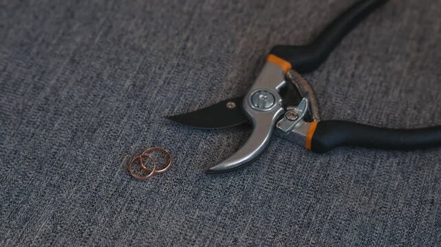 Symbol of relationship destruction rings and metal scissors reflect conflict and union ending with dramatic undertone