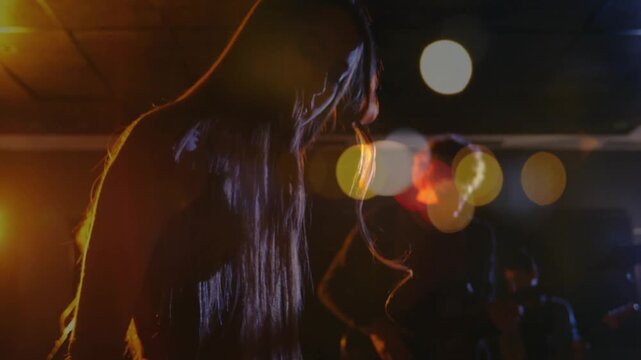 Camera pulling back, female keyboardist playing keys, rehearsing music, bokeh crossing hands