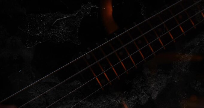 Vertical video: Musician hand entering and plucking bass strings for music recording, embers rising